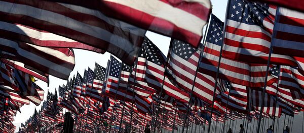 People walk amongst US national flags erected by students and staff from Pepperdine University as they pay their respects to honor the victims of the September 11, 2001 attacks in New York, at their campus in Malibu, California - Sputnik International