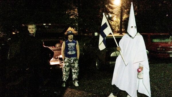 Sept. 24, 2015 photo, a group of demonstrators including one wearing an outfit in the style of the Ku Klux Klan stand in protest against refugees near a former army barracks in Hennala district in Lahti, Finland. - Sputnik International