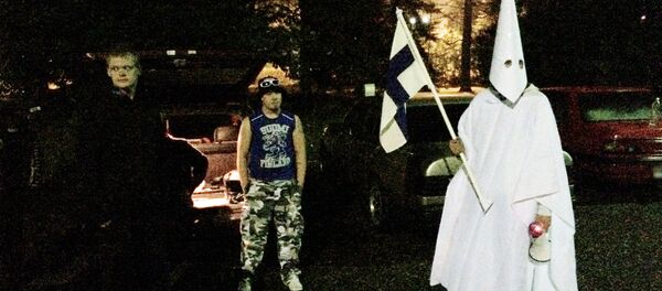 Sept. 24, 2015 photo, a group of demonstrators including one wearing an outfit in the style of the Ku Klux Klan stand in protest against refugees near a former army barracks in Hennala district in Lahti, Finland. Sept. 24, 2015 photo, a group of demonstrators including one wearing an outfit in the style of the Ku Klux Klan stand in protest against refugees near a former army barracks in Hennala district in Lahti, Finland. - Sputnik International