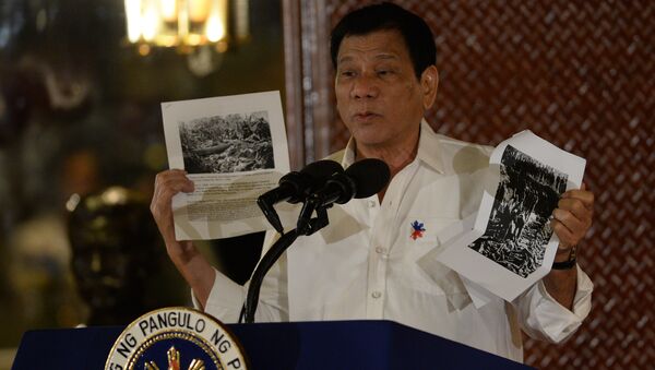 Philippine President Rodrigo Duterte holds up a photo and cites accounts of US troops who killed Muslims during the US's occupation of the Philippines in the early-1900s, during a speech at the Malacanang palace in Manila on September 12, 2016. - Sputnik International