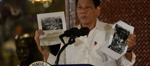 Philippine President Rodrigo Duterte holds up a photo and cites accounts of US troops who killed Muslims during the US's occupation of the Philippines in the early-1900s, during a speech at the Malacanang palace in Manila on September 12, 2016. Philippine President Rodrigo Duterte holds up a photo and cites accounts of US troops who killed Muslims during the US's occupation of the Philippines in the early-1900s, during a speech at the Malacanang palace in Manila on September 12, 2016. - Sputnik International
