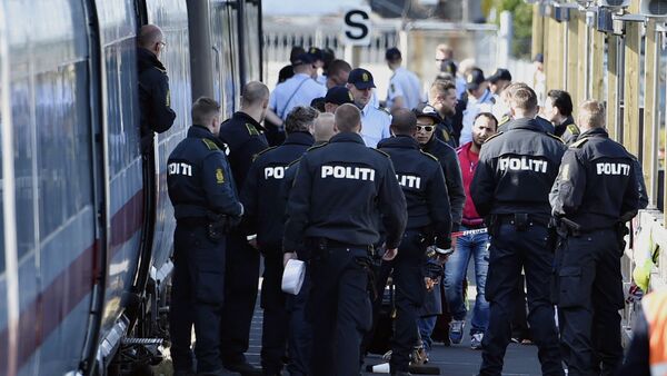 Danish police guards a train with migrants, mainly from Syria and Iraq, at Rodby railway station, southern Denmark - Sputnik International
