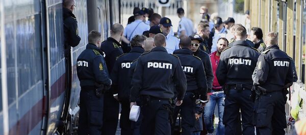 Danish police guards a train with migrants, mainly from Syria and Iraq, at Rodby railway station, southern Denmark - Sputnik International
