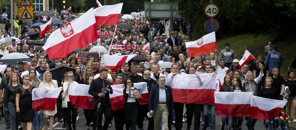 Members of the Polish community waves Polish flags as they march through Harlow exactly a week after the killing of Arek Jozwik in Harlow, Essex, east of London on September 3, 2016 Members of the Polish community waves Polish flags as they march through Harlow exactly a week after the killing of Arek Jozwik in Harlow, Essex, east of London on September 3, 2016 - Sputnik International
