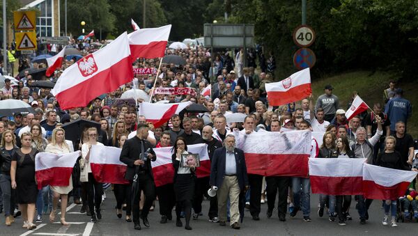 Members of the Polish community waves Polish flags as they march through Harlow exactly a week after the killing of Arek Jozwik in Harlow, Essex, east of London on September 3, 2016 - Sputnik International