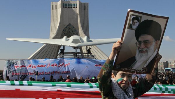 An Iranian boy holds a portrait of supreme leader, Ayatollah Ali khamenei as he walks past a replica of the captured US RQ-170 drone on display next to the Azadi (Freedom) tower during the 33rd anniversary of the Islamic revolution in Tehran on February 11, 2012 - Sputnik International
