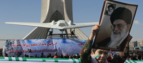 An Iranian boy holds a portrait of supreme leader, Ayatollah Ali khamenei as he walks past a replica of the captured US RQ-170 drone on display next to the Azadi (Freedom) tower during the 33rd anniversary of the Islamic revolution in Tehran on February 11, 2012 - Sputnik International