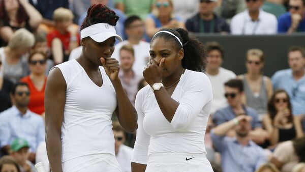 Serena Williams, right with her sister and playing partner Venus Williams of the US talks as they play against Elena Vesnina of Russia and Yekaterina Makarova of Russia during their women's doubles tennis match on the eleventh  day of the Wimbledon Tennis Championships in London, July 7, 2016 - Sputnik International