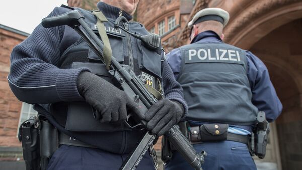 A police officer holds a submachine gun at the main train station in Giessen, central Germany, Friday, March 25, 2016 - Sputnik International