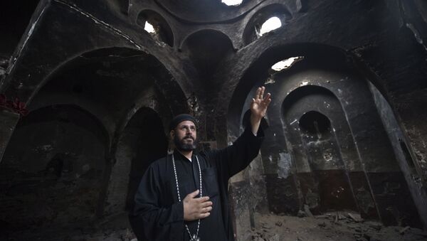 Delga's Coptic priest Yuannas points at the damage in the historical Blessed Virgin church following an attack by masked Islamist men the previous month in the town of Delga, in the central Egyptian province of Minya, some of 400 kilometres south of Cairo, on September 29, 2013 - Sputnik International