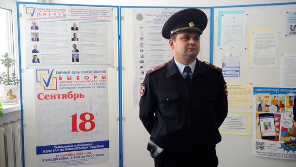 A police officer at a polling station during the preparation for the single election day on September 18 - Sputnik International