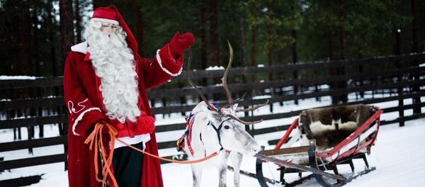 Santa Claus waves as he stands with a reindeer and sled outside Rovaniemi, Finnish Lapland on December 15, 2011 Santa Claus waves as he stands with a reindeer and sled outside Rovaniemi, Finnish Lapland on December 15, 2011 - Sputnik International