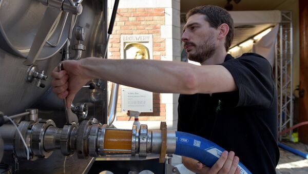 An employee of De Halve Maan brewery connects a pipe to feed beer into a truck in Bruges, September 15, 2016 - Sputnik International