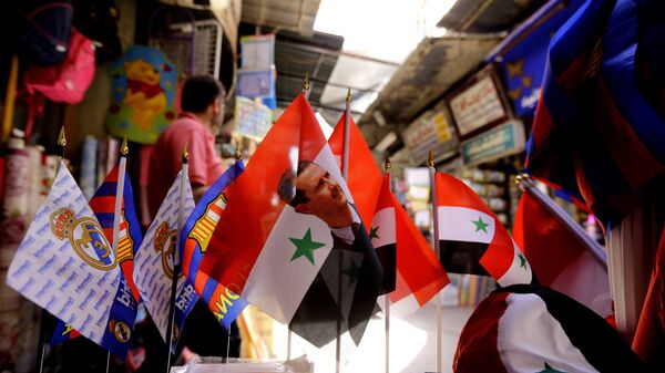 Syrian flags bearing the portrait of President Bashar al-Assad are displayed at the Hamidiyeh popular market in the old part of the capital Damascus on June 13, 2016 - Sputnik International