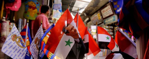 Syrian flags bearing the portrait of President Bashar al-Assad are displayed at the Hamidiyeh popular market in the old part of the capital Damascus on June 13, 2016 - Sputnik International