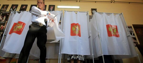 A Russian navy serviceman walks out of a voting booth at a polling station during the Russian parliamentary election in Sevastopol, Crimea, September 18, 2016. - Sputnik International