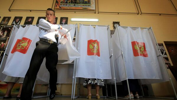 A Russian navy serviceman walks out of a voting booth at a polling station during the Russian parliamentary election in Sevastopol, Crimea, September 18, 2016. - Sputnik International