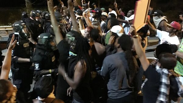 Protestors demonstrate in front of police officers wearing riot gear after police fatally shot Keith Lamont Scott in the parking lot of an apartment complex in Charlotte, North Carolina, U.S. September 20, 2016 - Sputnik International