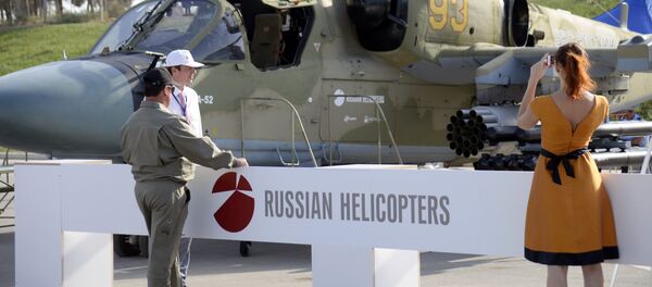 A woman as she takes a photo of a Russian military helicopter KA-52 at the ADEX 2014 International Defence Industry Exhibition in Baku on September 11, 2014 A woman as she takes a photo of a Russian military helicopter KA-52 at the ADEX 2014 International Defence Industry Exhibition in Baku on September 11, 2014 - Sputnik International