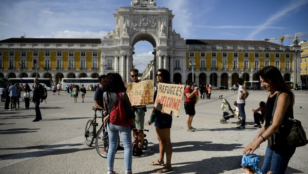 People hold posters welcoming refugees during a rally in support of migrants and refugees as part of the European Day of Action in Lisbon (File) - Sputnik International