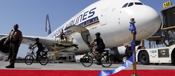 A Singapore Airlines Airbus 380 is parked behind a red carpet and stantion holding the ceremonial ribbon that was cut at the grand opening of the Tom Bradley International Terminal at Los Angeles International Airport. File photo - Sputnik International