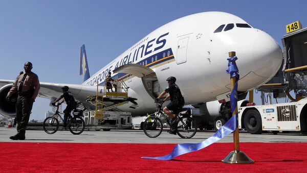 A Singapore Airlines Airbus 380 is parked behind a red carpet and stantion holding the ceremonial ribbon that was cut at the grand opening of the Tom Bradley International Terminal at Los Angeles International Airport. File photo - Sputnik International