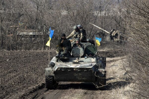 Ukrainian servicemen ride atop armored vehicle with a canon in tow and Ukrainian flags, near the village of Fedorivka, eastern Ukraine, Friday, Feb. 27, 2015 Ukrainian servicemen ride atop armored vehicle with a canon in tow and Ukrainian flags, near the village of Fedorivka, eastern Ukraine, Friday, Feb. 27, 2015 - Sputnik International