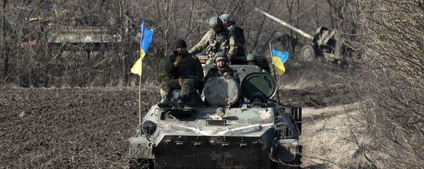 Ukrainian servicemen ride atop armored vehicle with a canon in tow and Ukrainian flags, near the village of Fedorivka, eastern Ukraine, Friday, Feb. 27, 2015 Ukrainian servicemen ride atop armored vehicle with a canon in tow and Ukrainian flags, near the village of Fedorivka, eastern Ukraine, Friday, Feb. 27, 2015 - Sputnik International