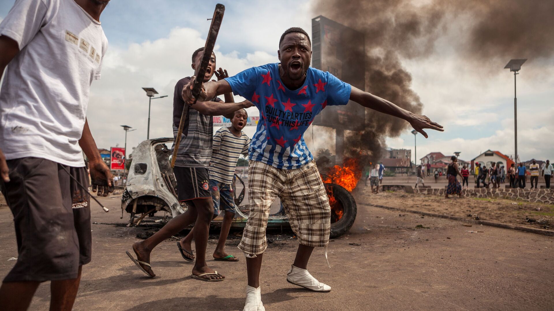 Демонстранты на фоне горящих автомобилей в Киншасе, Конго - Sputnik International, 1920, 02.08.2022