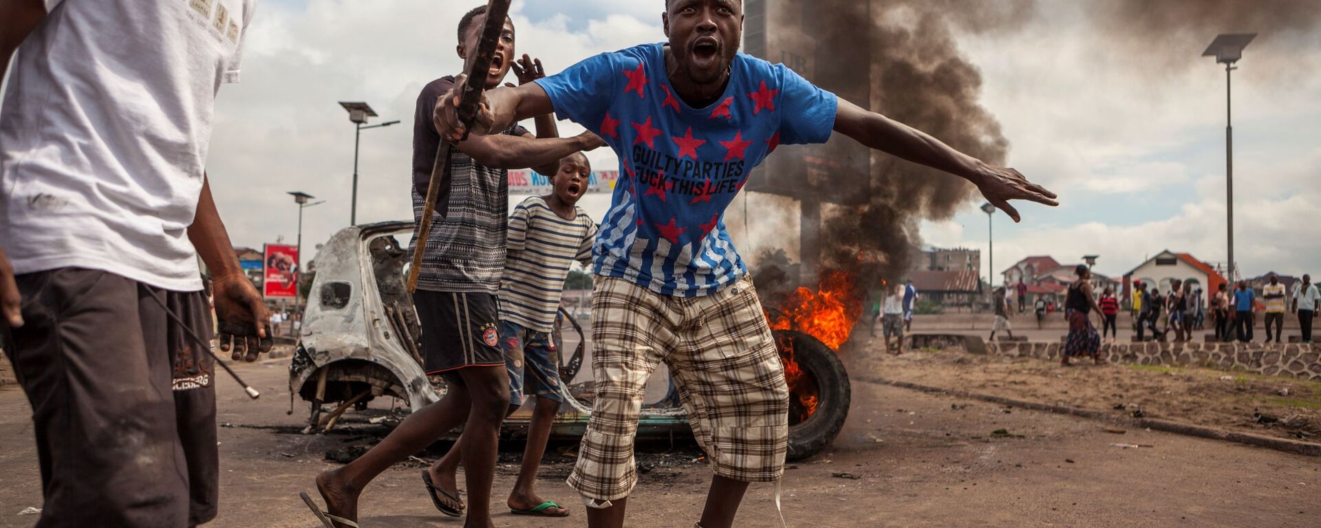 Демонстранты на фоне горящих автомобилей в Киншасе, Конго - Sputnik International, 1920, 02.08.2022