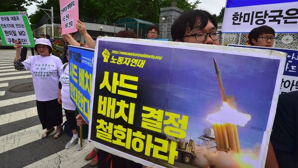 South Korean activists hold placards during a rally against a plan on deployment of the US-built Terminal High Altitude Area Defense (THAAD), outside the Defence Ministry in Seoul on July 13, 2016. Activists have staged a series of rallies voicing their opposition to the missile defense system's deployment in their region. - Sputnik International