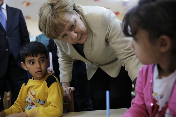 German Chancellor Angela Merkel talks with refugee children at a preschool, during a visit to a refugee camp on April 23, 2016 on the Turkish-Syrian border in Gaziantep German Chancellor Angela Merkel talks with refugee children at a preschool, during a visit to a refugee camp on April 23, 2016 on the Turkish-Syrian border in Gaziantep - Sputnik International