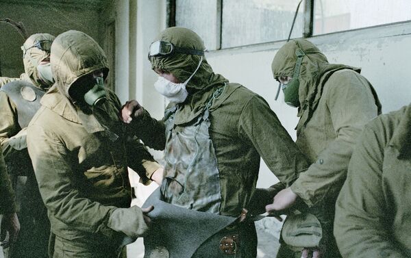 Personnel assigned to remove debris from the roof of the damaged Chernobyl Nuclear Plant unit don protective suits. - Sputnik International
