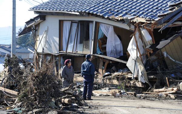 Local residents look at a damaged house caused by a tsunami in Minamisoma, Fukushima Prefecture. - Sputnik International