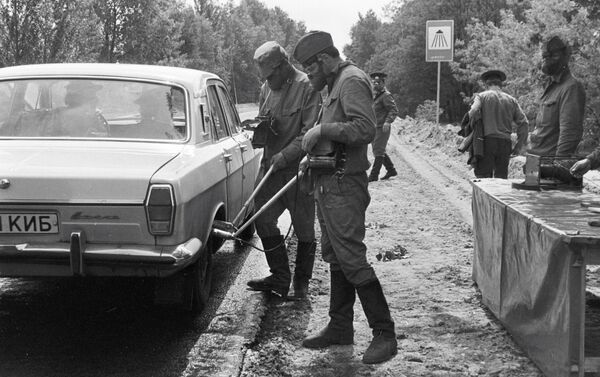 Soldiers check radiation levels of cars leaving the city of Chernobyl. - Sputnik International