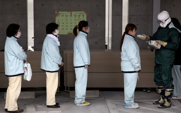 People line up for radiation screening at Koryama in Fukushima prefecture on March 21, 2011. - Sputnik International