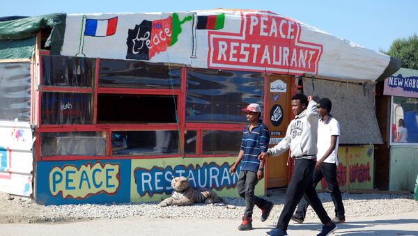 Migrants pass by the Peace Restaurant in the northern area of the camp called the Jungle in Calais, France, September 7, 2016 - Sputnik International