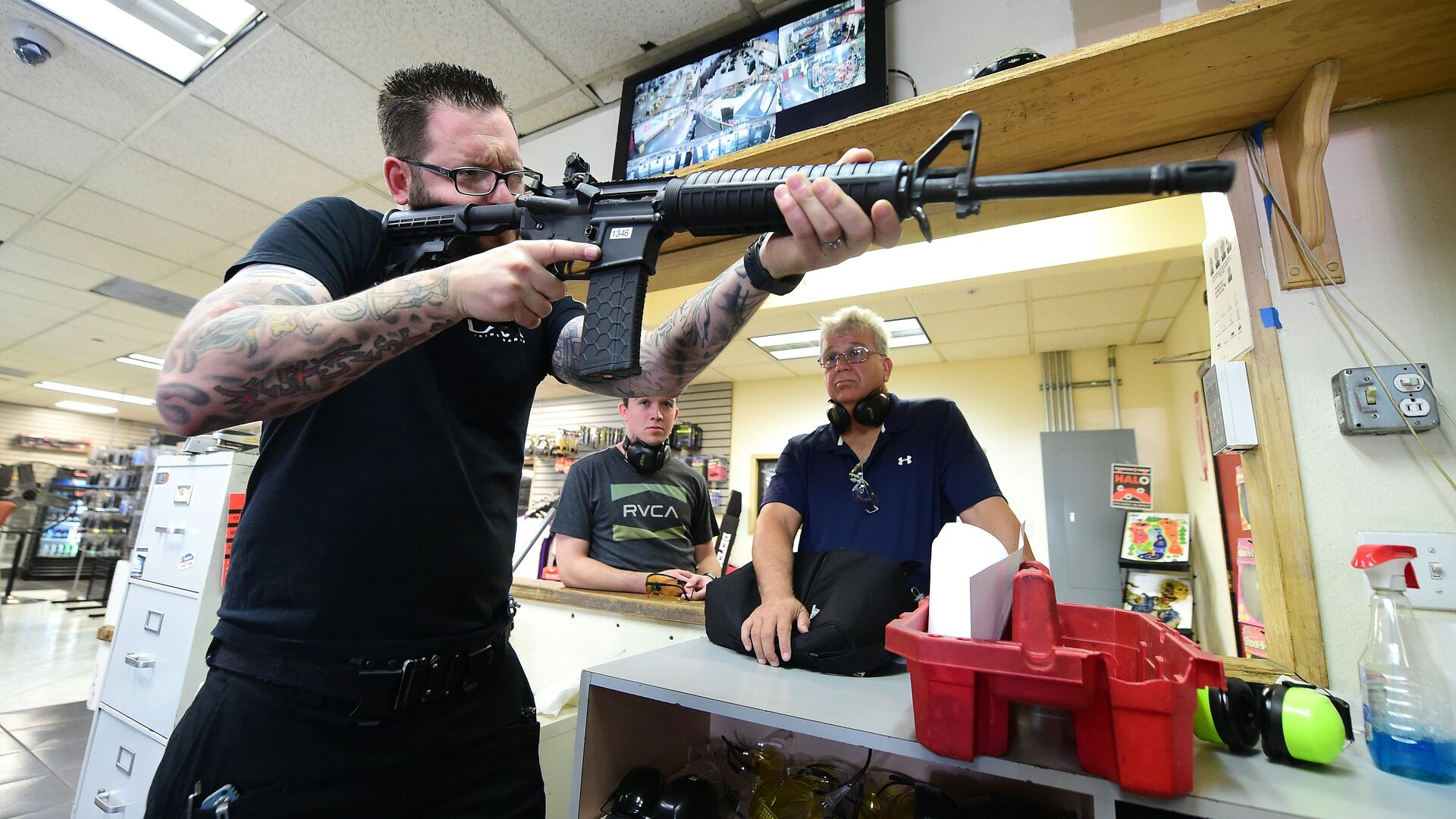 LAX Firing Range employee Tommy Bushnell demonstrates how to use an AR15 rifle to gun enthusiasts waiting to shoot at targets in Inglewood, California on September 7, 2016 - Sputnik International, 1920, 03.06.2022
