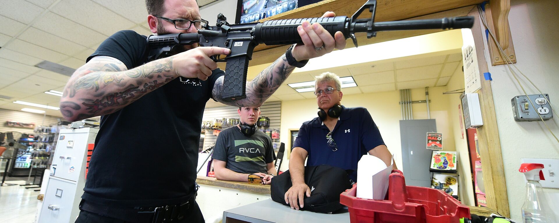 LAX Firing Range employee Tommy Bushnell demonstrates how to use an AR15 rifle to gun enthusiasts waiting to shoot at targets in Inglewood, California on September 7, 2016 - Sputnik International, 1920, 03.06.2022