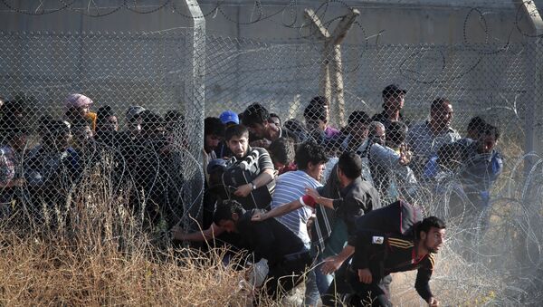 File photo taken from the Turkish side of the border between Turkey and Syria, in Akcakale, Sanliurfa province, southeastern Turkey, Syrian refugees burst into Turkey after breaking the border fence and crossing from Syria cross into Turkey - Sputnik International