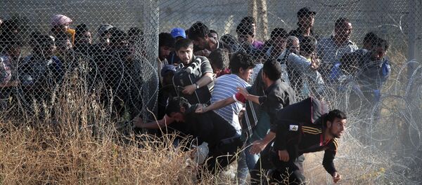 File photo taken from the Turkish side of the border between Turkey and Syria, in Akcakale, Sanliurfa province, southeastern Turkey, Syrian refugees burst into Turkey after breaking the border fence and crossing from Syria cross into Turkey - Sputnik International