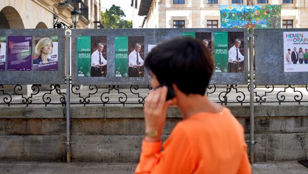 A woman walks past election posters for Basque nationalist Party (PNV) candidate, Inigo Urkullu, in the Basque town of Guernica, northern Spain, September 21, 2016. - Sputnik International