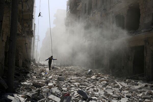 A man walks on the rubble of damaged buildings in Aleppo, Syria September 25, 2016 - Sputnik International