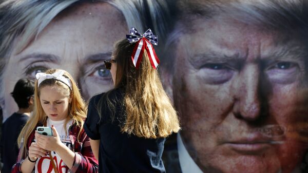 People pause near a bus adorned with large photos of candidates Hillary Clinton and Donald Trump before the presidential debate. - Sputnik International