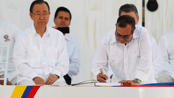 Marxist rebel leader Rodrigo Londono (R), better known by the nom de guerre Timochenko, signs an accord ending a half-century war that killed a quarter of a million people next to United Nations Secretary-General Ban Ki-moon (L), Mexican President Enrique Pena Nieto (2nd L) and Colombian President Juan Manuel Santos (partially obscured) in Cartagena, Colombia September 26, 2016. - Sputnik International