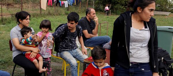 A group of people wait to get accommodation at the entrance of a camp for refugees and migrants in the Belgrade suburb of Krnjaca, Serbia, September 21, 2016. A group of people wait to get accommodation at the entrance of a camp for refugees and migrants in the Belgrade suburb of Krnjaca, Serbia, September 21, 2016. - Sputnik International
