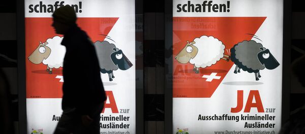 A man walks past backlit posters of the right-wing populist Swiss People's Party (SVP) that translate from German as Finally Create Security to advertise their initiative for the eviction of criminal foreigners in Zurich on February 25, 2016. - Sputnik International