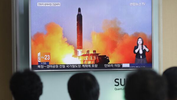 People watch a TV news channel airing an image of North Korea's ballistic missile launch published in North Korea's Rodong Sinmun newspaper at the Seoul Railway Station in Seoul. (File) - Sputnik International