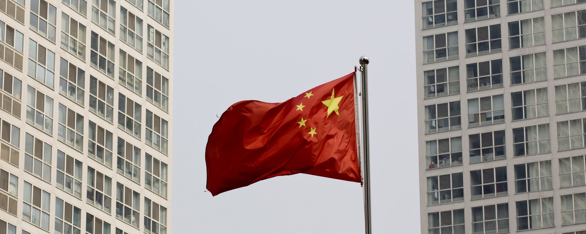 A Chinese national flag flutters in the wind in between a high-rise residential and office complex in Beijing, China. (File) - Sputnik International, 1920, 24.02.2023
