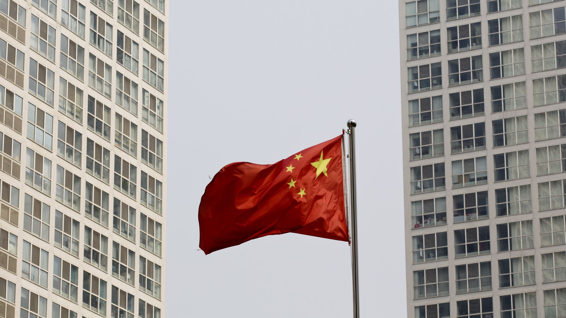 A Chinese national flag flutters in the wind in between a high-rise residential and office complex in Beijing, China. (File) - Sputnik International, 1920, 24.02.2023
